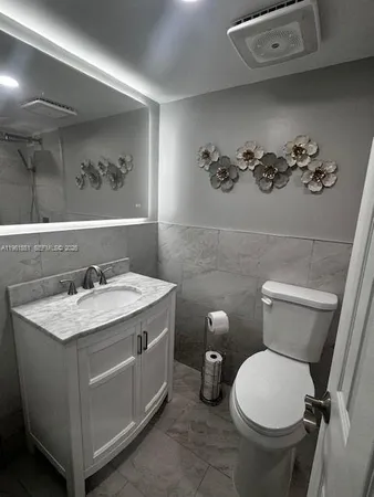 a bathroom with a sink mirror and toilet