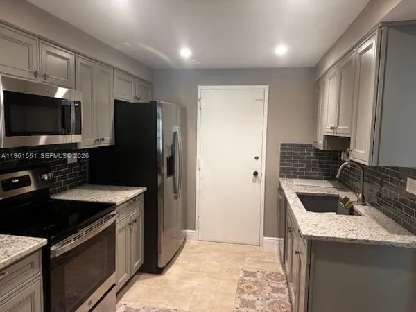 a kitchen that has a sink and a stove in it