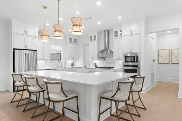a kitchen with stainless steel appliances kitchen island granite countertop a table chairs and a refrigerator