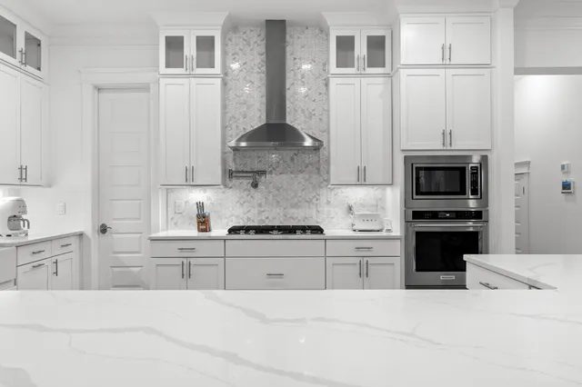 a kitchen with granite countertop a stove sink and refrigerator