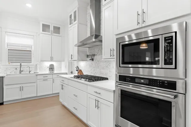 a kitchen with stainless steel appliances white cabinets and stove
