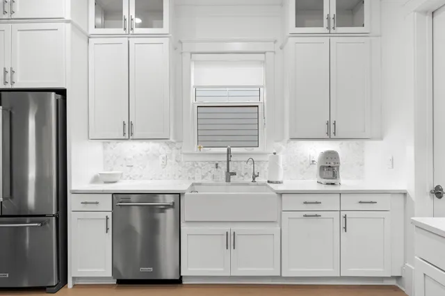 a kitchen with stainless steel appliances granite countertop a sink and a refrigerator