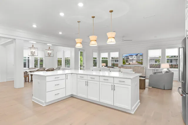a large white kitchen with a large island in the center and white cabinets