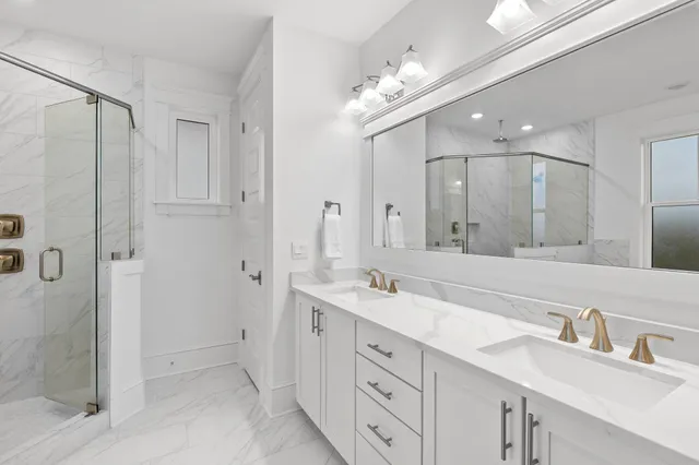 a spacious bathroom with a double vanity sink mirror and shower