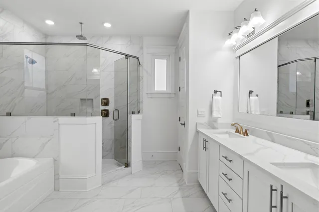 a spacious bathroom with a double vanity sink a large mirror a shower and bathtub