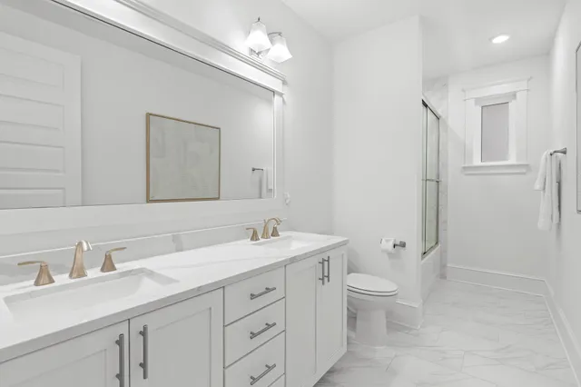 a bathroom with a granite countertop sink a toilet and a mirror