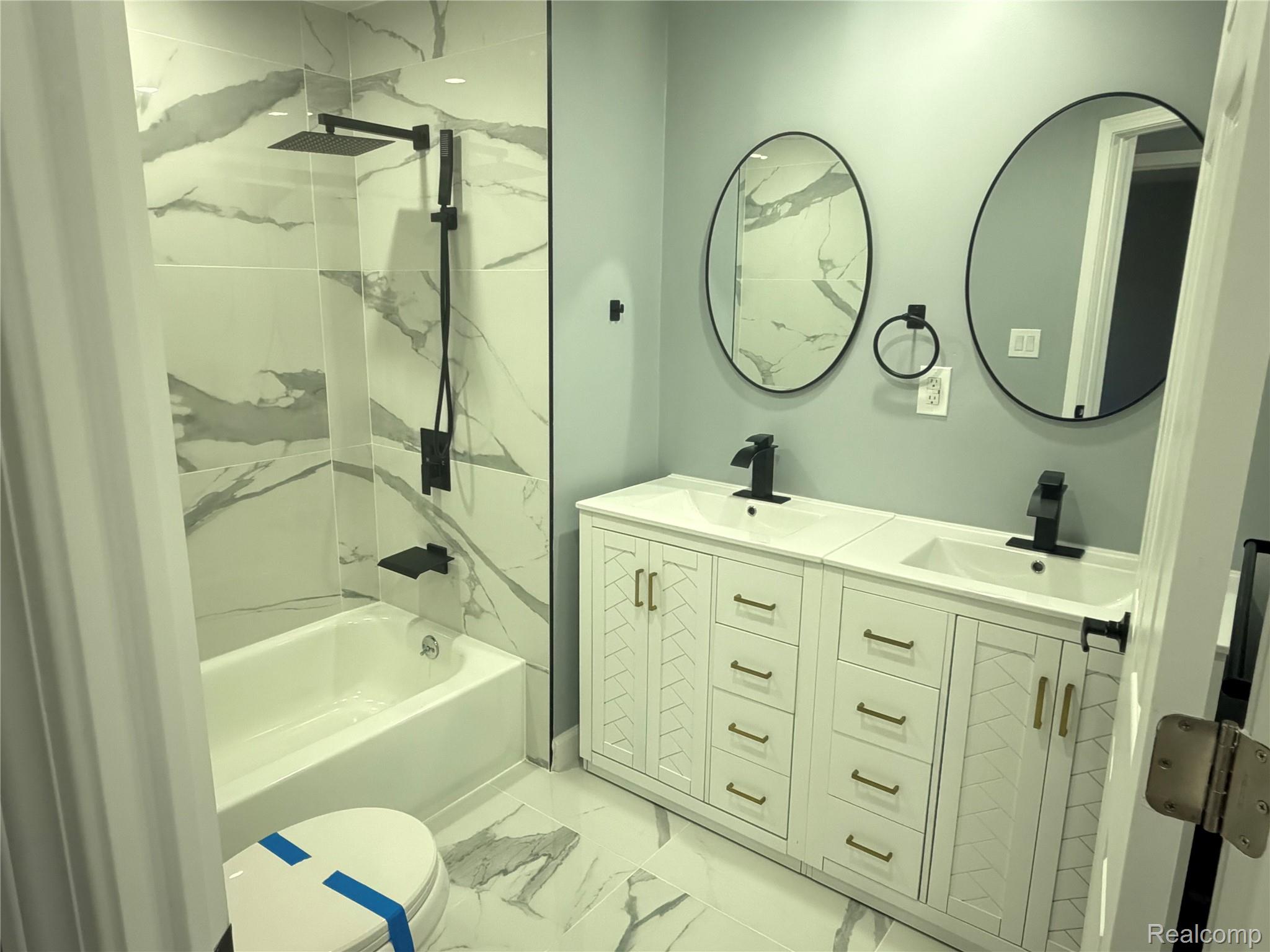 20698 Coachwood Road Riverview, MI 48193 - Photo 25 of 37 Bathroom featuring a combined bath / shower with marble appearance, light marble finish flooring, and double vanity
