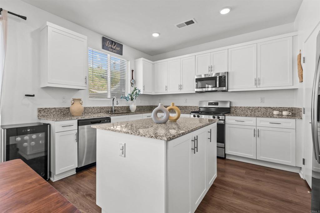 228 Hass Lane Fallbrook, CA 92028 - Photo 11 of 26 a kitchen with granite countertop white cabinets and white appliances