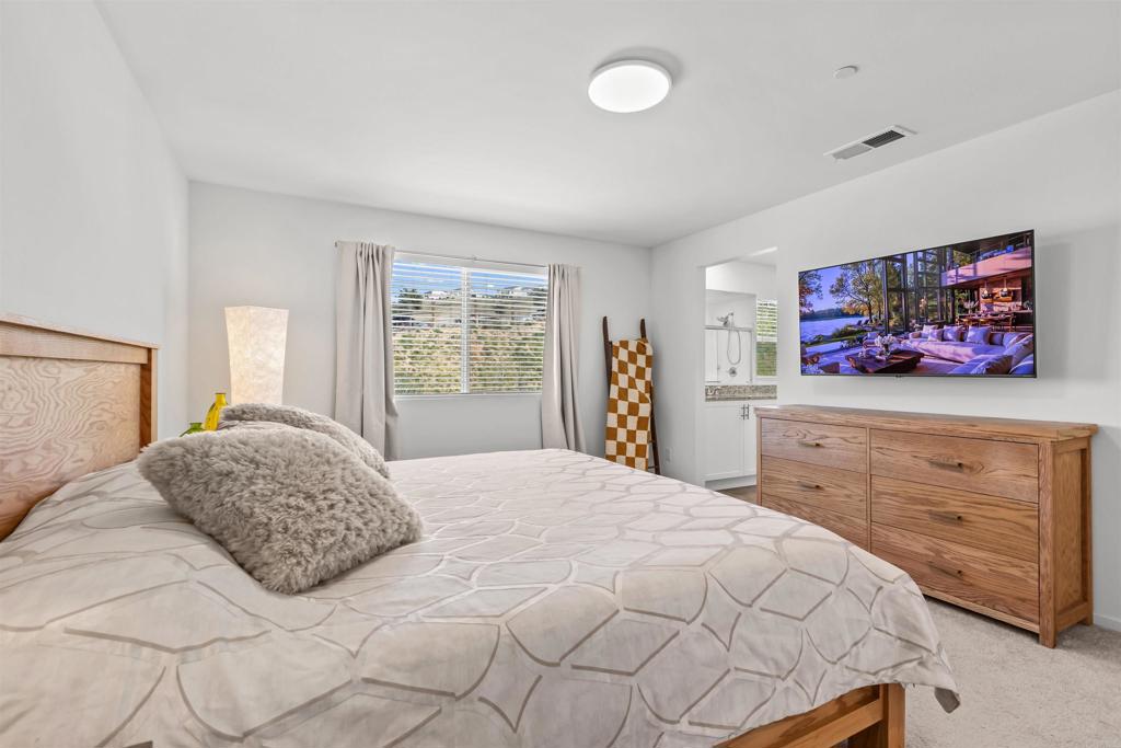 228 Hass Lane Fallbrook, CA 92028 - Photo 13 of 26 a bedroom with a bed and dresser with mirror