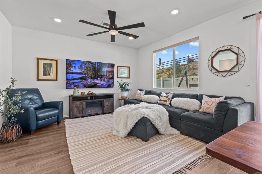 228 Hass Lane Fallbrook, CA 92028 - Photo 7 of 26 a living room with furniture a chandelier and a flat screen tv