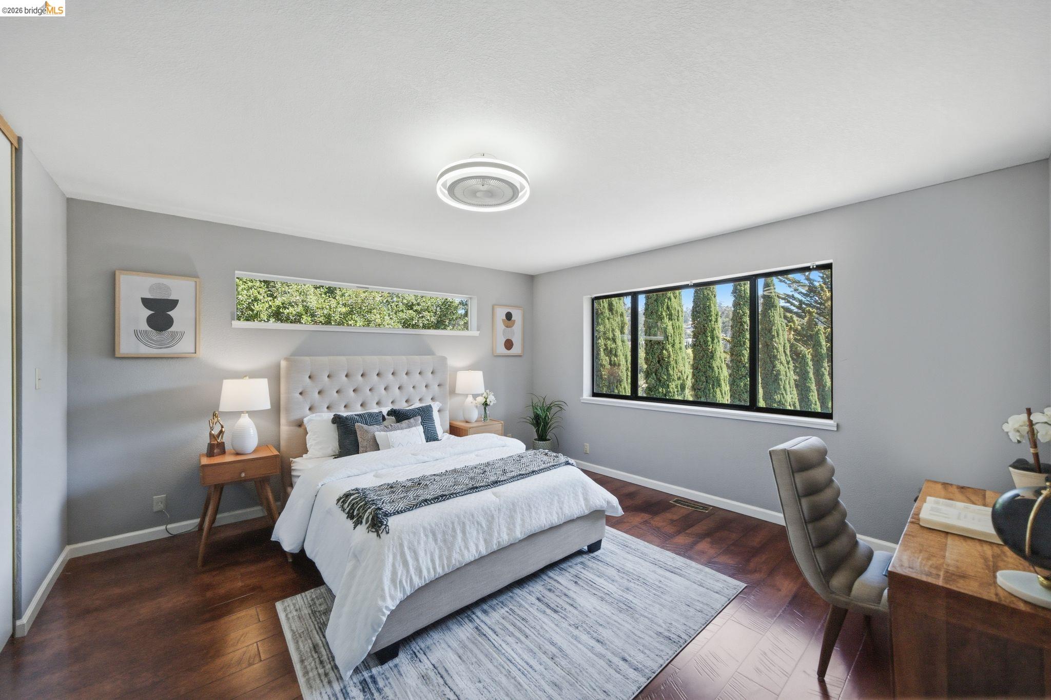 11133 Golf Links Road Oakland, CA 94605 - Photo 37 of 57 Spacious room featuring wood-finish flooring, a contemporary ceiling light fixture, and light gray wall paint