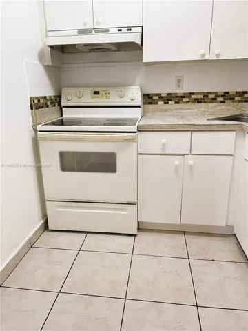 a stove top oven sitting inside of a kitchen