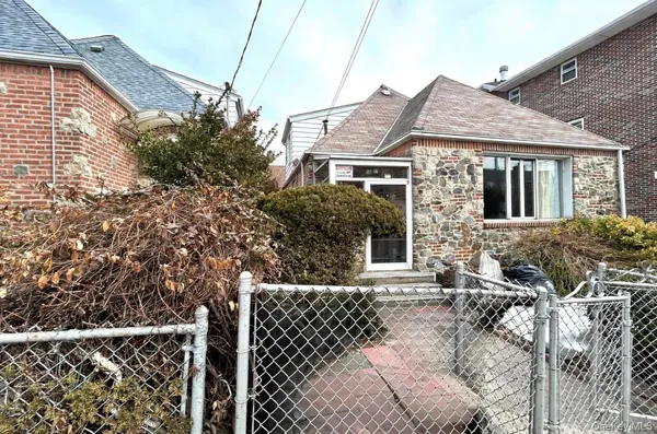 a front view of a house with a tree
