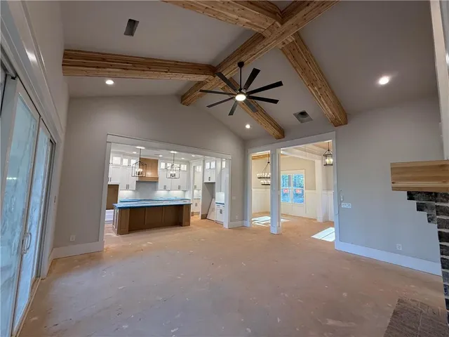 a view of a dining room with furniture a chandelier and kitchen view