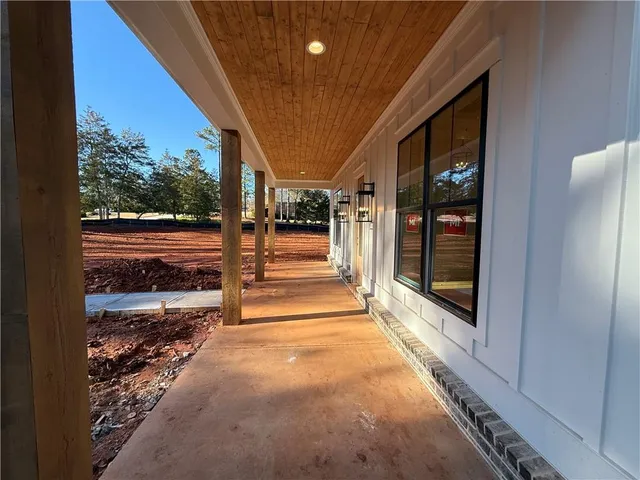 a view of a hallway with wooden floor and a living room