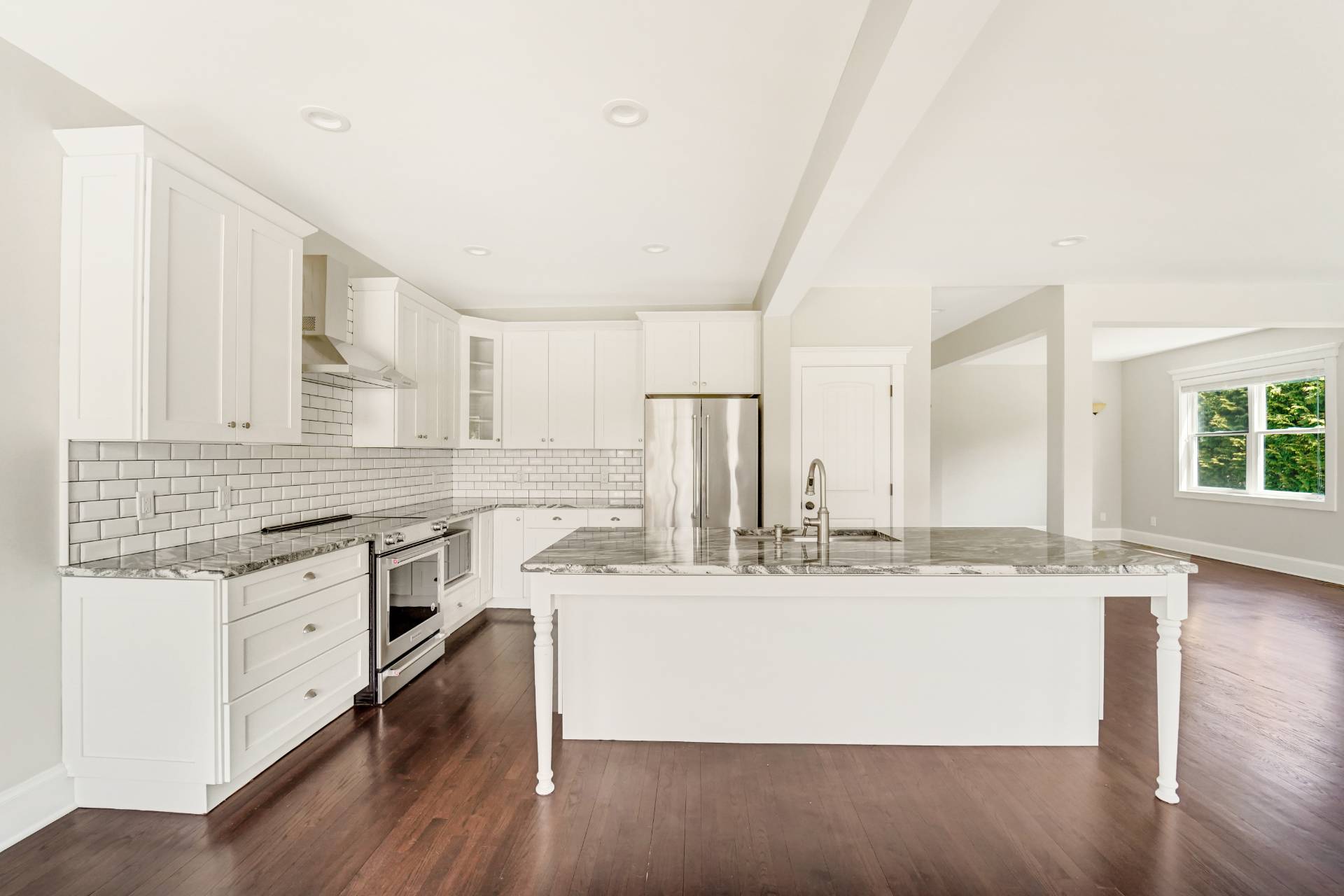 64 Romana Drive Hampton Bays, NY 11946 - Photo 11 of 29 a large white kitchen with kitchen island granite countertop a sink and white cabinets