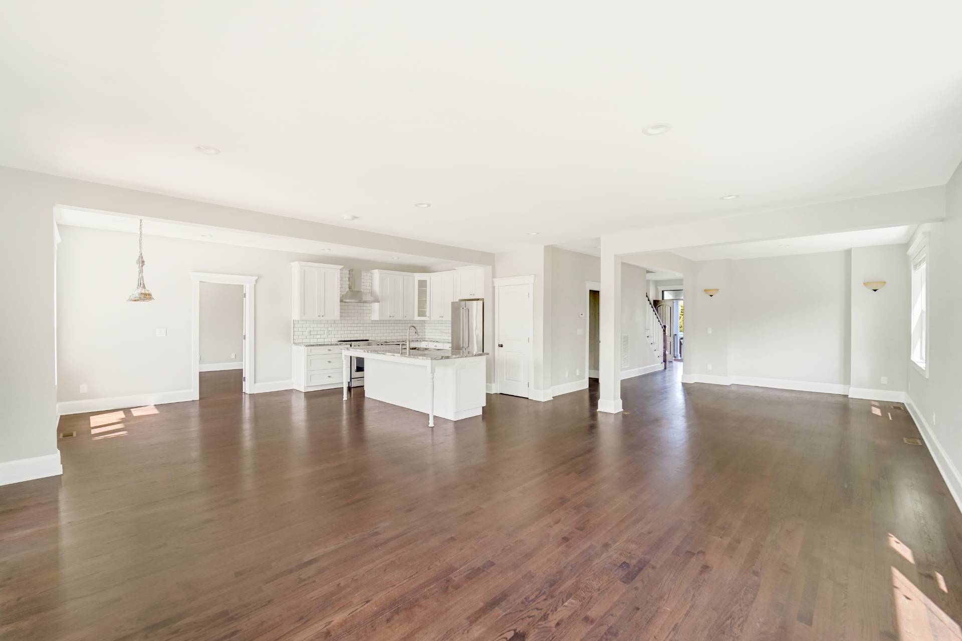 64 Romana Drive Hampton Bays, NY 11946 - Photo 12 of 29 a view of empty room with wooden floor and kitchen view