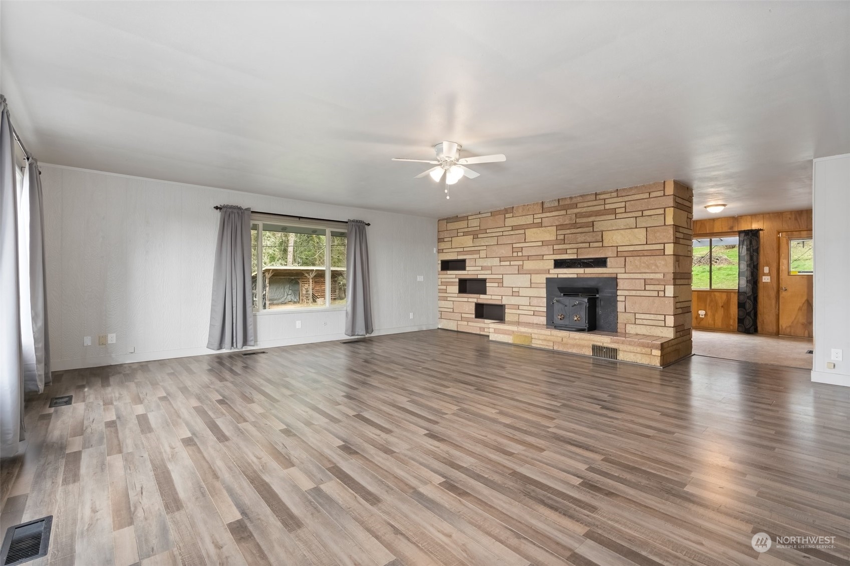 137 Wallace Road Chehalis, WA 98532 - Photo 4 of 39 an empty room with wooden floor fireplace and windows