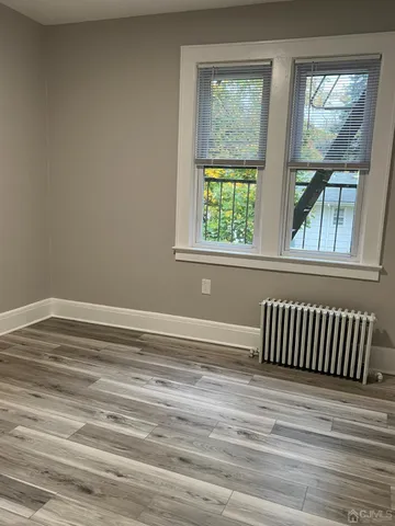 a view of a room with wooden floor and a window