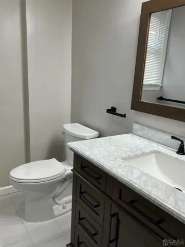 a bathroom with a granite countertop toilet sink and mirror