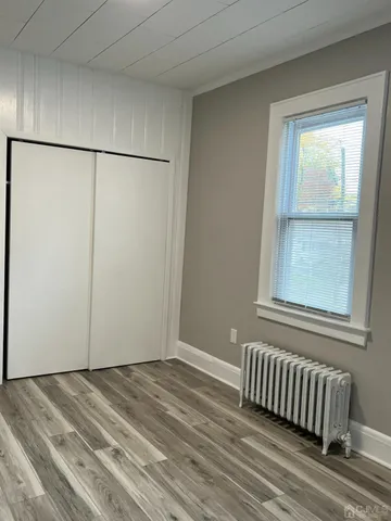 a view of a room that has a window and a bed