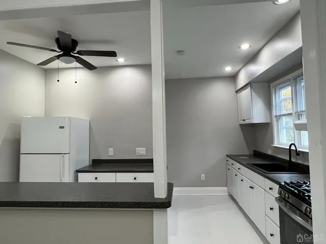 a kitchen with kitchen island a sink appliances and cabinets