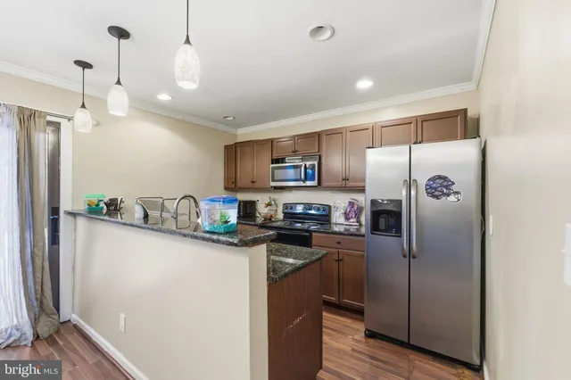 a kitchen with stainless steel appliances granite countertop a refrigerator a sink a stove a microwave and island