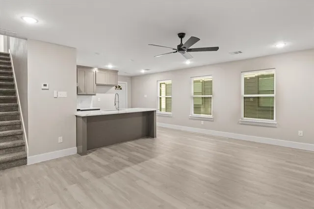 a kitchen with granite countertop a sink and a stove top oven with wooden floor