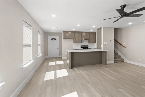 a kitchen with stainless steel appliances a refrigerator a sink dishwasher with a stove and wooden floor