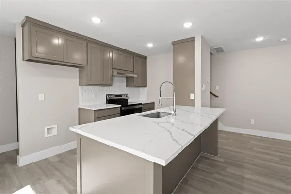 a large kitchen with kitchen island a sink stainless steel appliances and cabinets