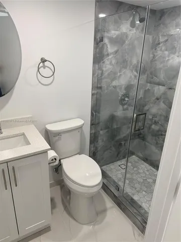 a white toilet sitting next to a shower