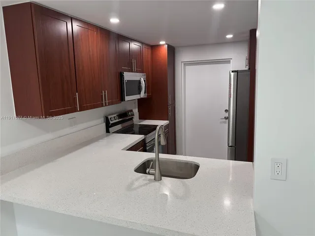 a kitchen with a refrigerator and microwave
