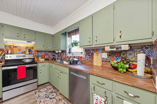 a view of a kitchen filled with an empty room and wooden floor