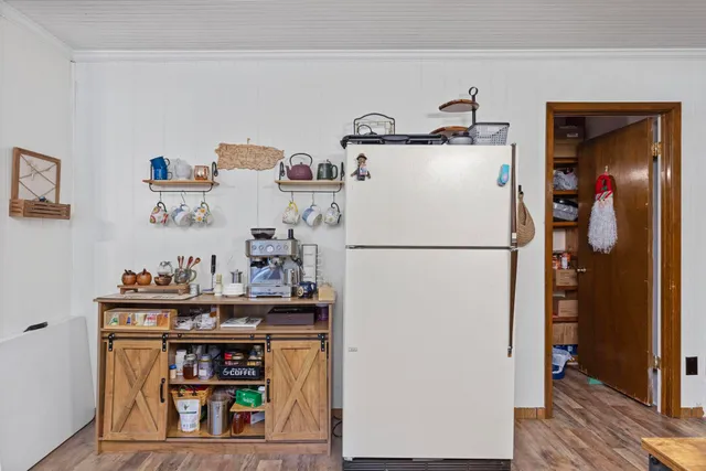 a white refrigerator freezer and a wooden floor