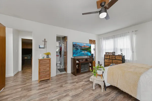 a bedroom with a bed and a flat tv screen on dresser