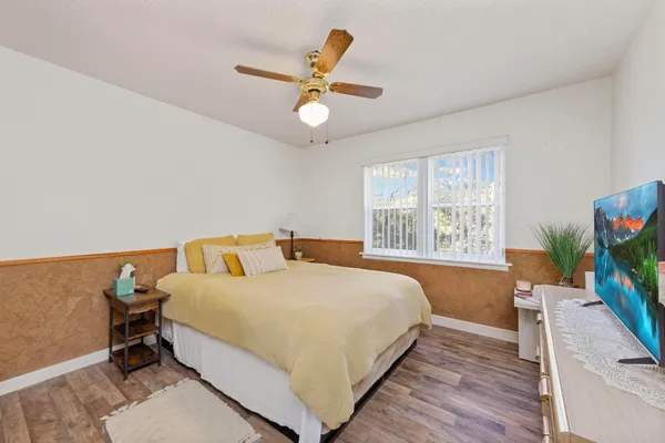 a room with a bed window and a flat screen tv