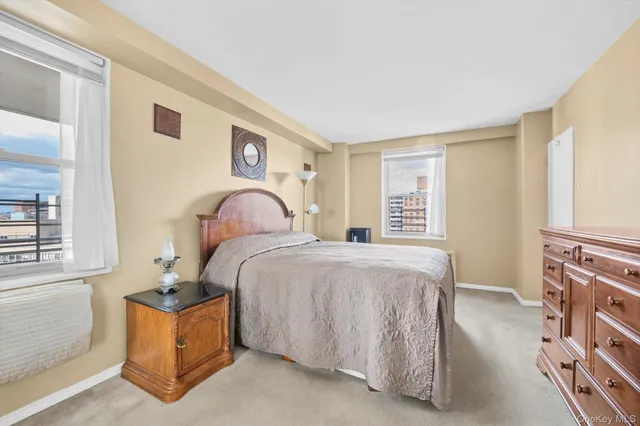 a bedroom with a bed and a dresser with the mirror