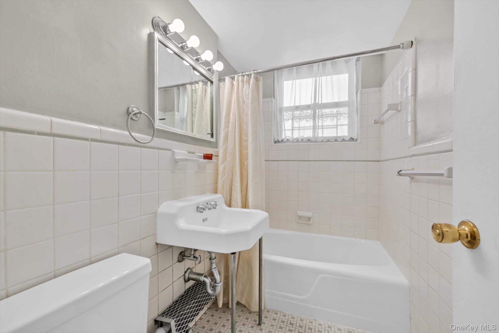 61-15 97th Street, Unit 12A Queens, NY 11374 - Photo 16 of 25 a bathroom with a sink and a bathtub