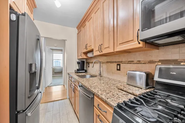 a kitchen with stainless steel appliances granite countertop a sink and a stove