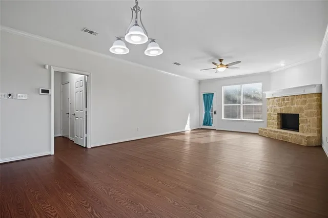 a view of a livingroom with wooden floor and a fireplace