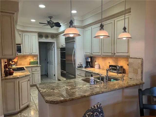 a kitchen with stainless steel appliances granite countertop a sink a stove and a refrigerator