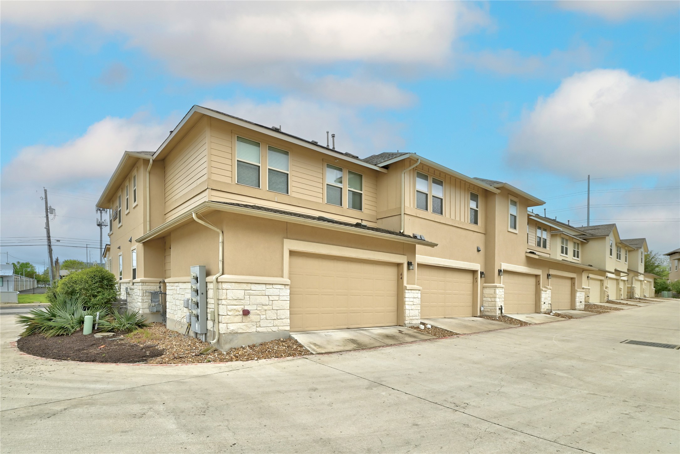6814 East Riverside Drive, Unit 64 Austin, TX 78741 - Photo 3 of 17 Rows of attractive townhomes feature integrated garages and varied exterior finishes.