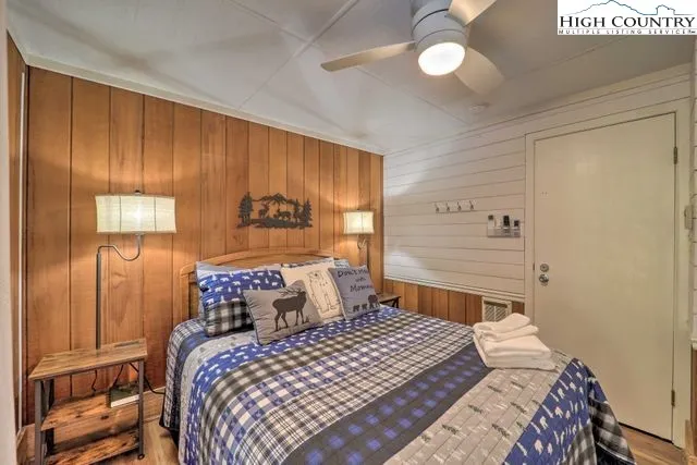 a bedroom with a large bed and a closet with wooden floor