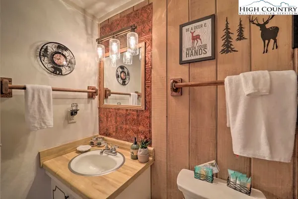 a bathroom with a sink mirror vanity and toilet