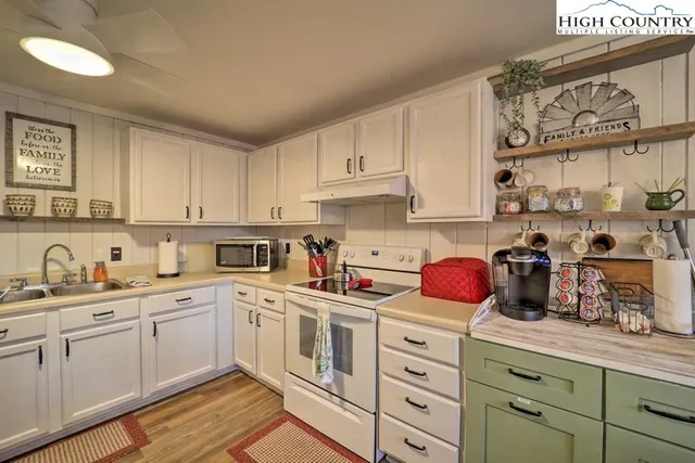 a kitchen with white cabinets and white appliances