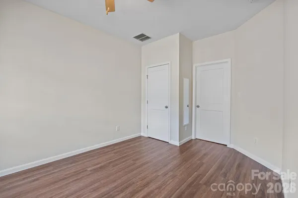 an empty room with windows and fan
