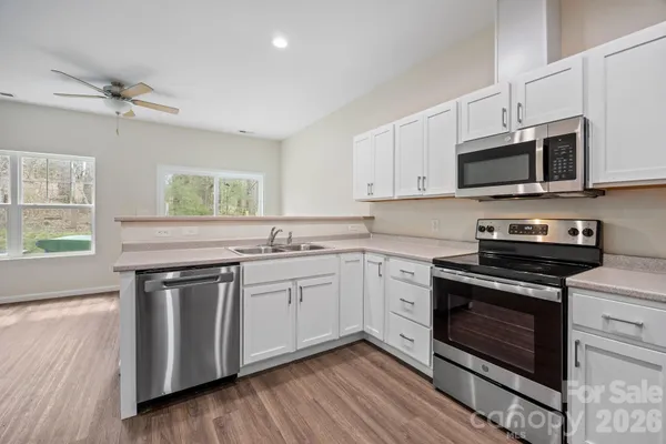 a kitchen with white cabinets stainless steel appliances and a sink