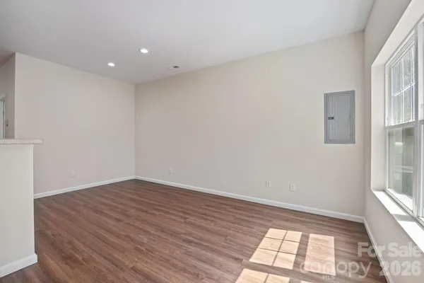 a kitchen with stainless steel appliances granite countertop a dining table chairs refrigerator and microwave