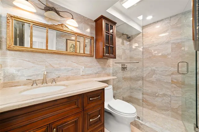 a bathroom with a sink a toilet and shower