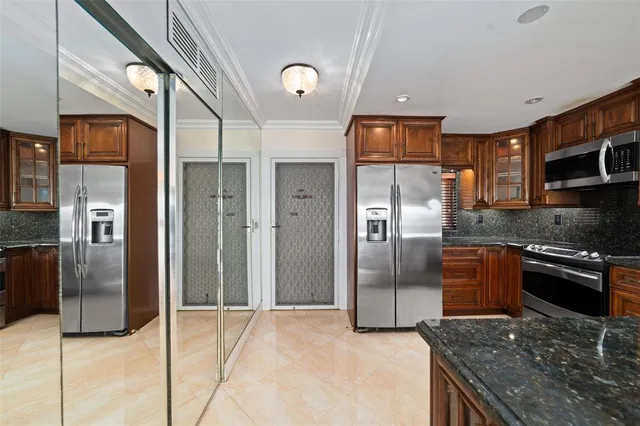 a kitchen with stainless steel appliances granite countertop a refrigerator and a stove